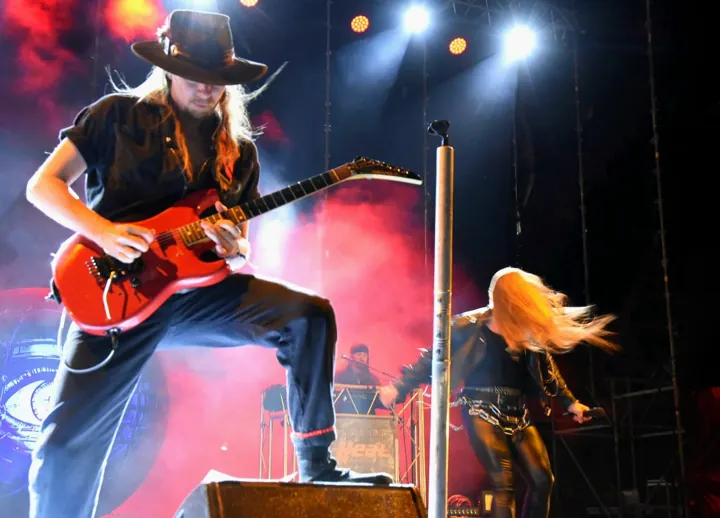 Guitarrista con sombrero y guitarra roja durante el festival