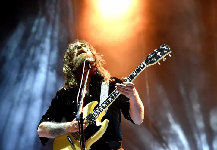 Guitarrista tocando bajo los focos anaranjados